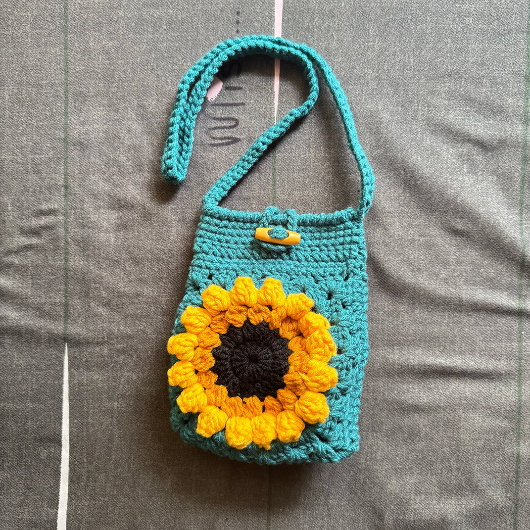 Handmade turquoise Sunflower Mini Bag with a yellow crochet flower
